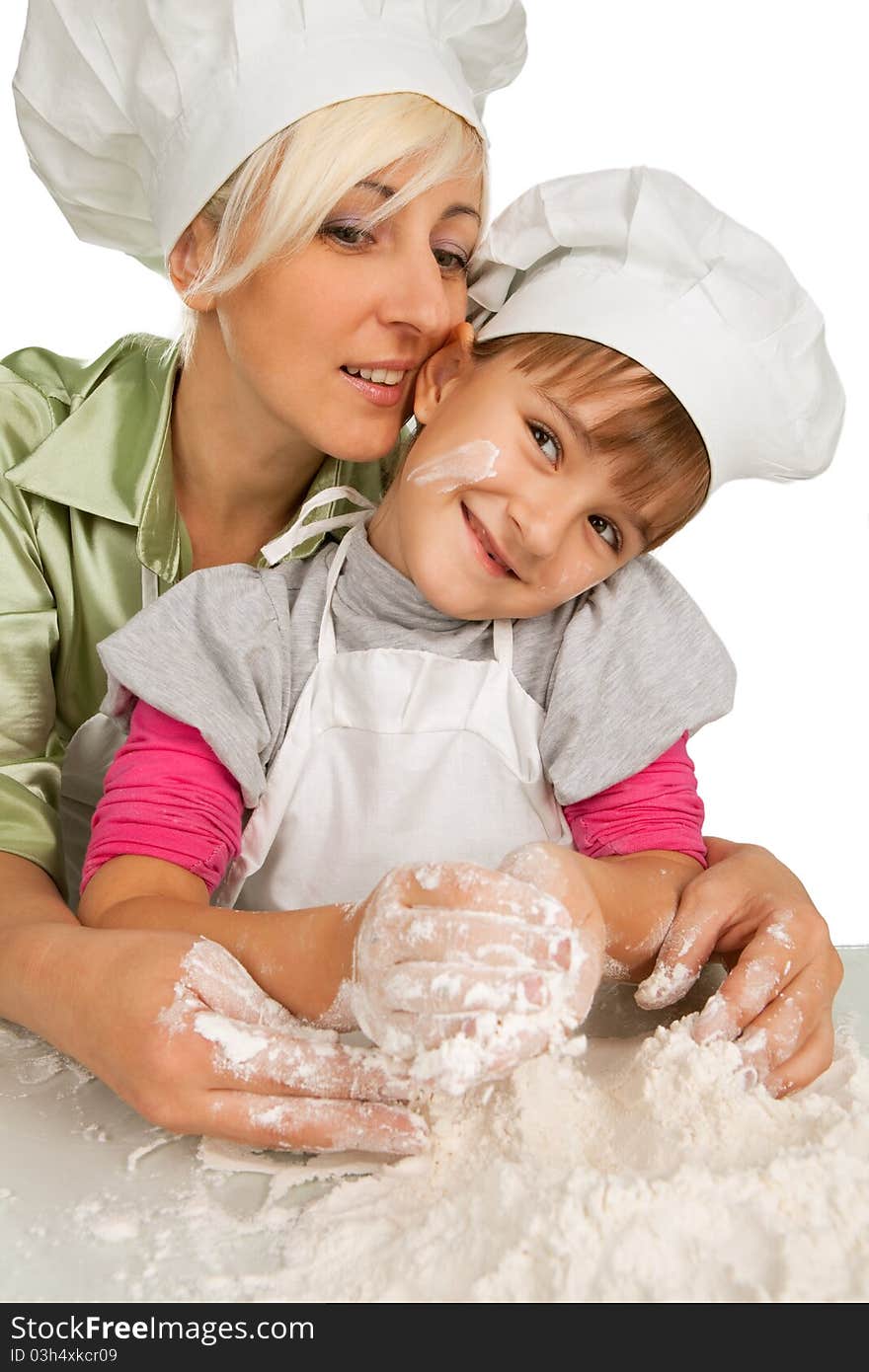 Happy, blond caucasian mother and daughter preparing dough and having fun