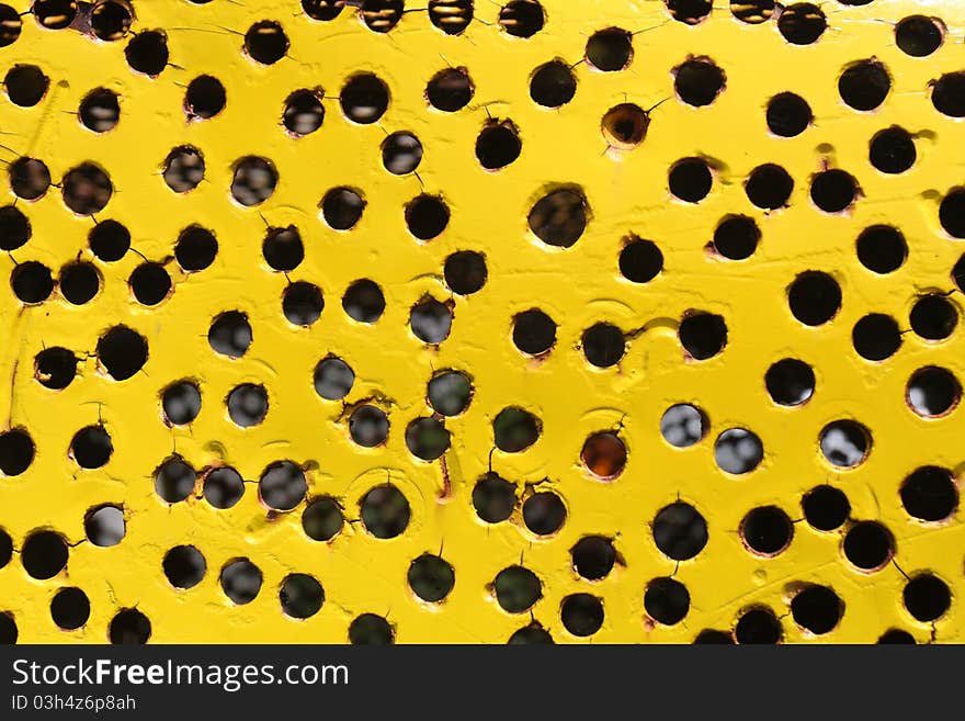 Holes on  yellow metal plate. Holes on  yellow metal plate