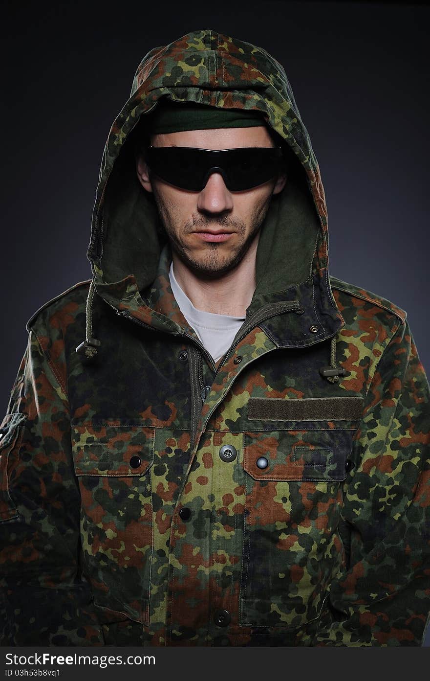 Portrait of soldier in camouflage and ammunition . studio shot