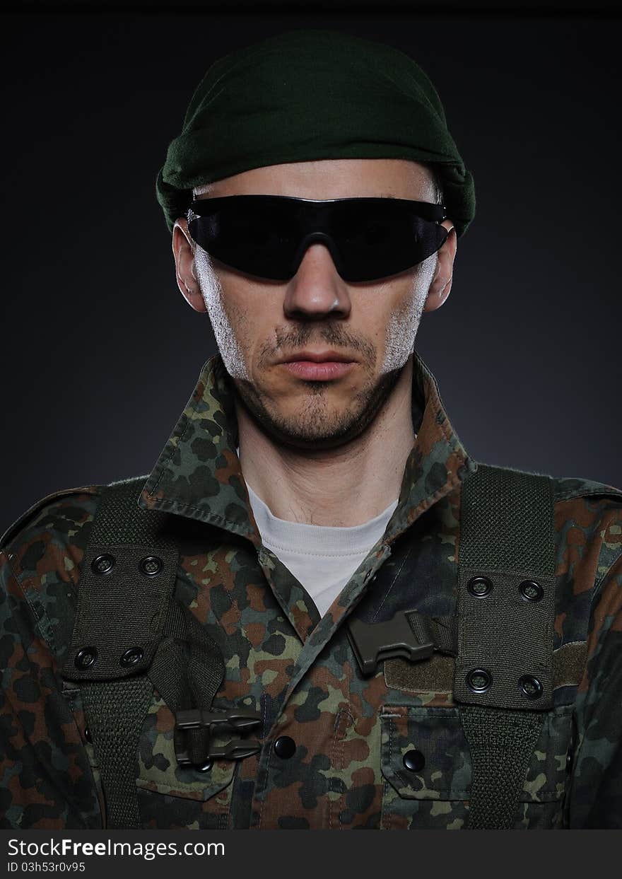 Portrait of soldier in camouflage and ammunition . studio shot