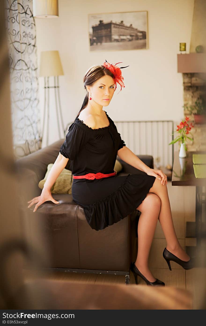 Beautiful girl wearing evening dress sitting on sofa in restaurant. Beautiful girl wearing evening dress sitting on sofa in restaurant.