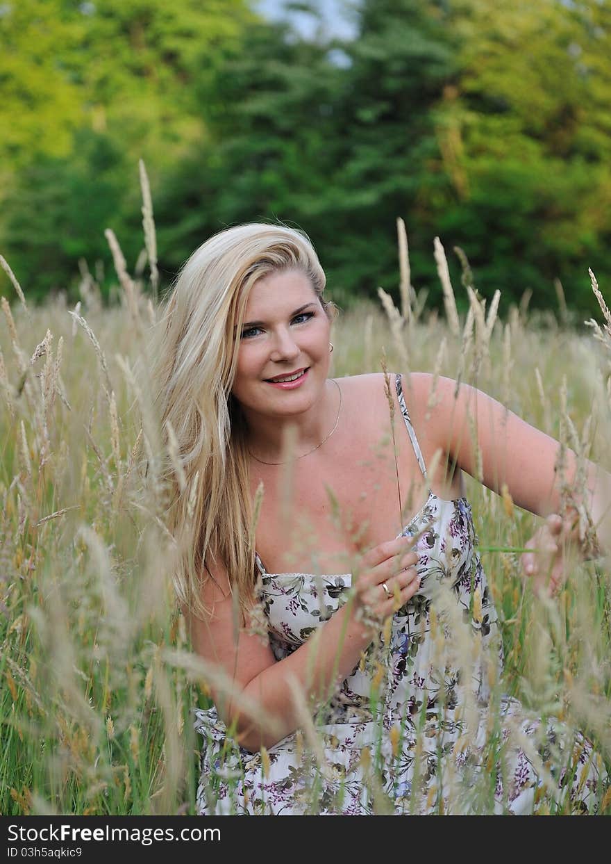 Pretty summer woman on yellow wheat field