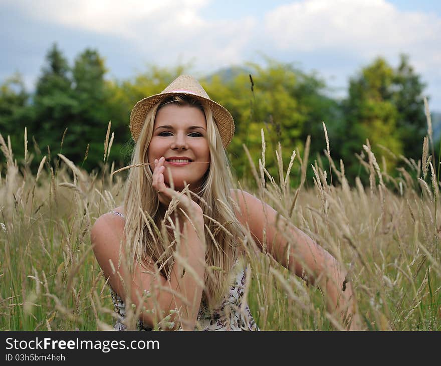 Pretty summer woman on yellow wheat field