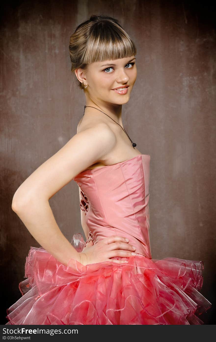 Portrait of the beauty young blond girl near the brown wall