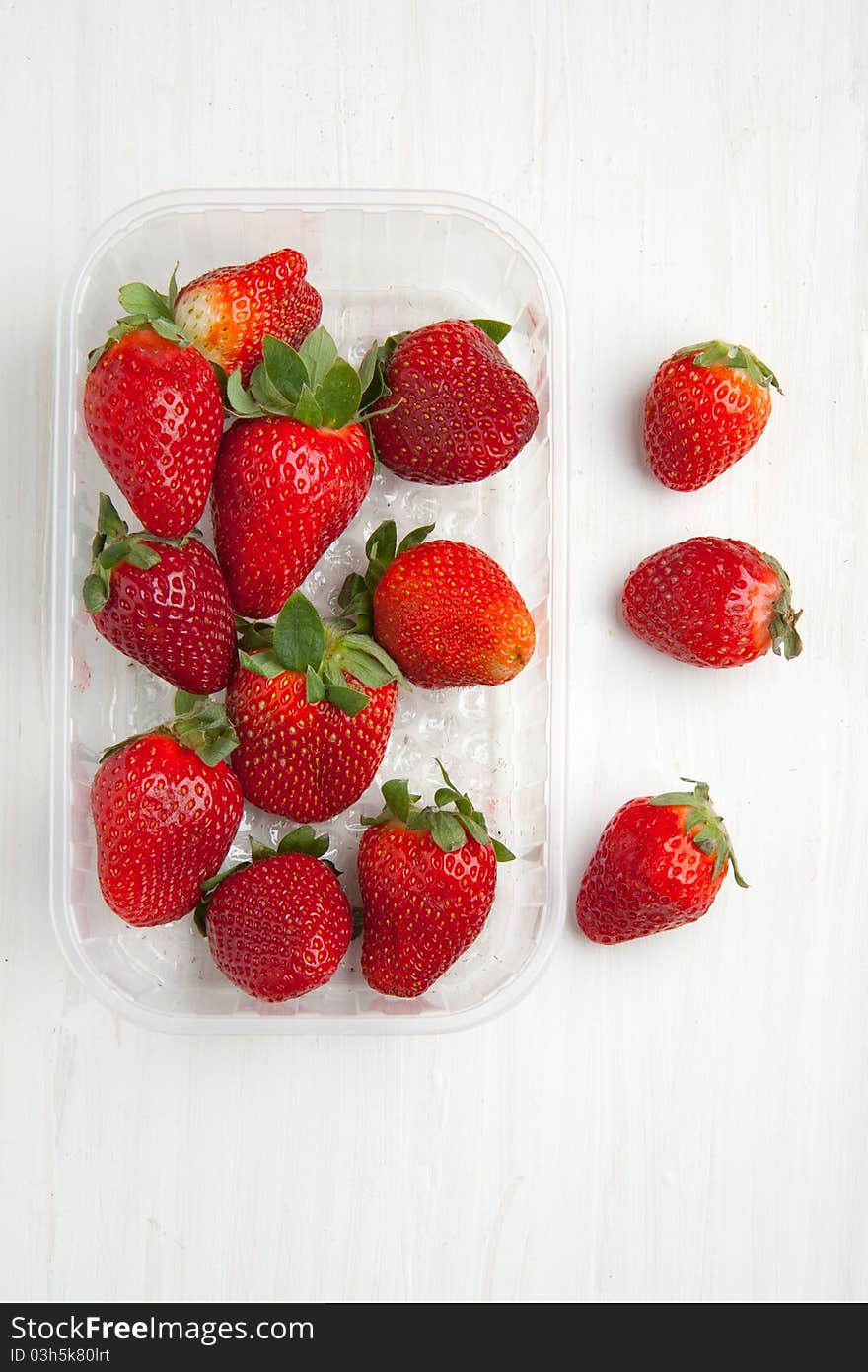 Top view on box of fresh strawberries on white table. Top view on box of fresh strawberries on white table