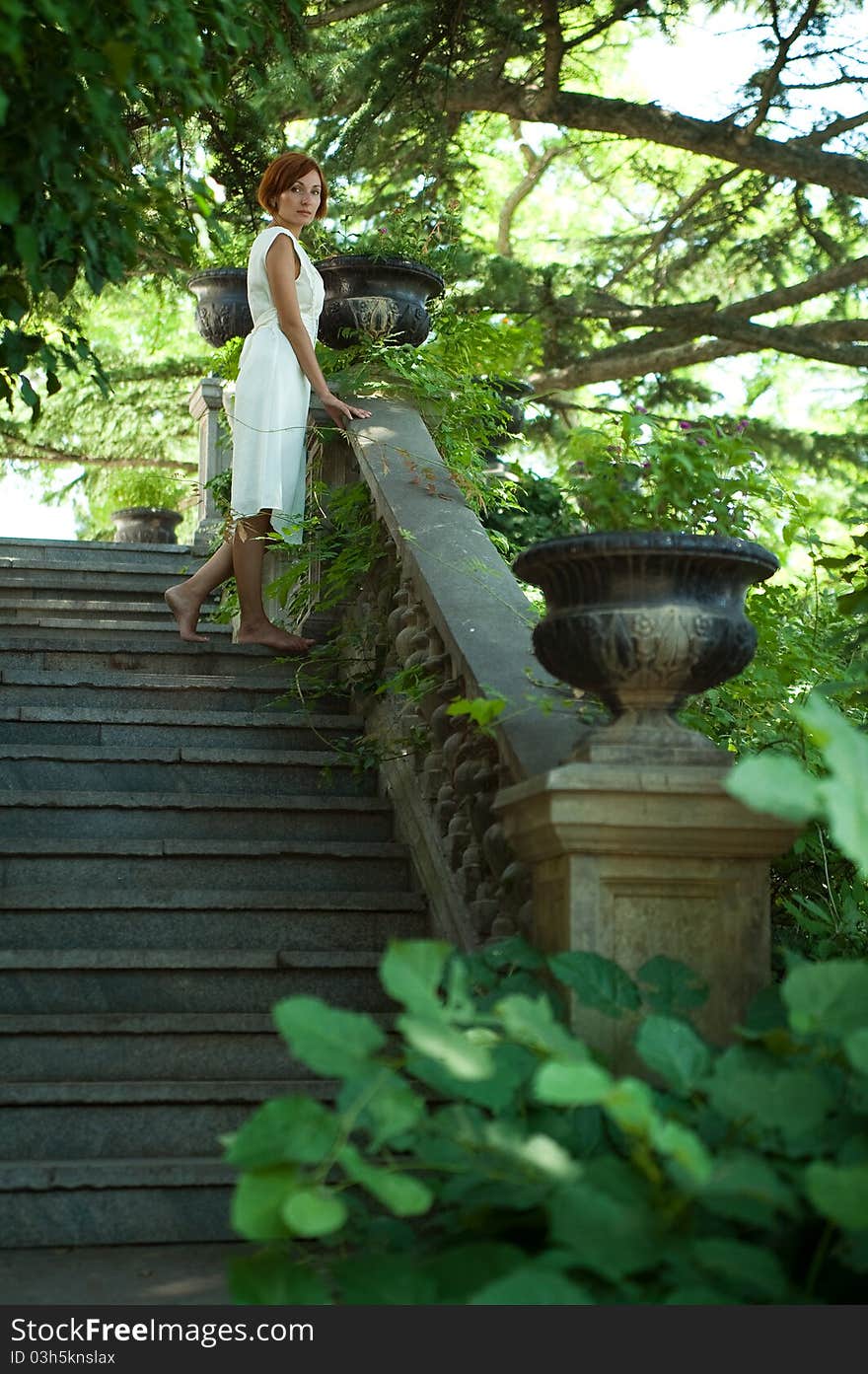 Beautiful young woman strolling through the old summer garden. Beautiful young woman strolling through the old summer garden