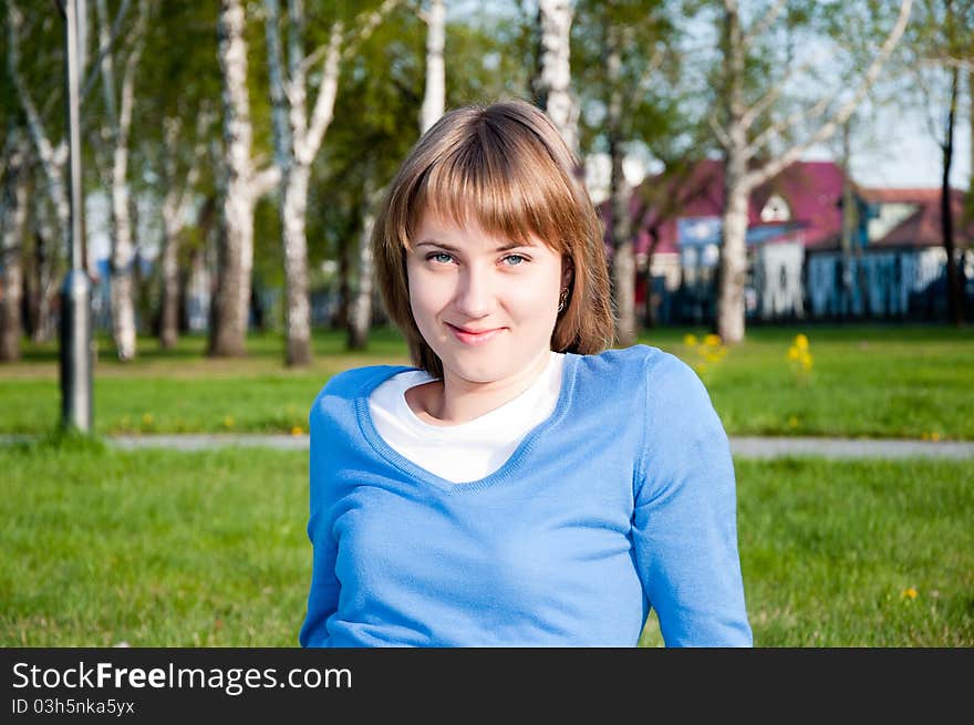 Smiling Girl Sitting In The Park