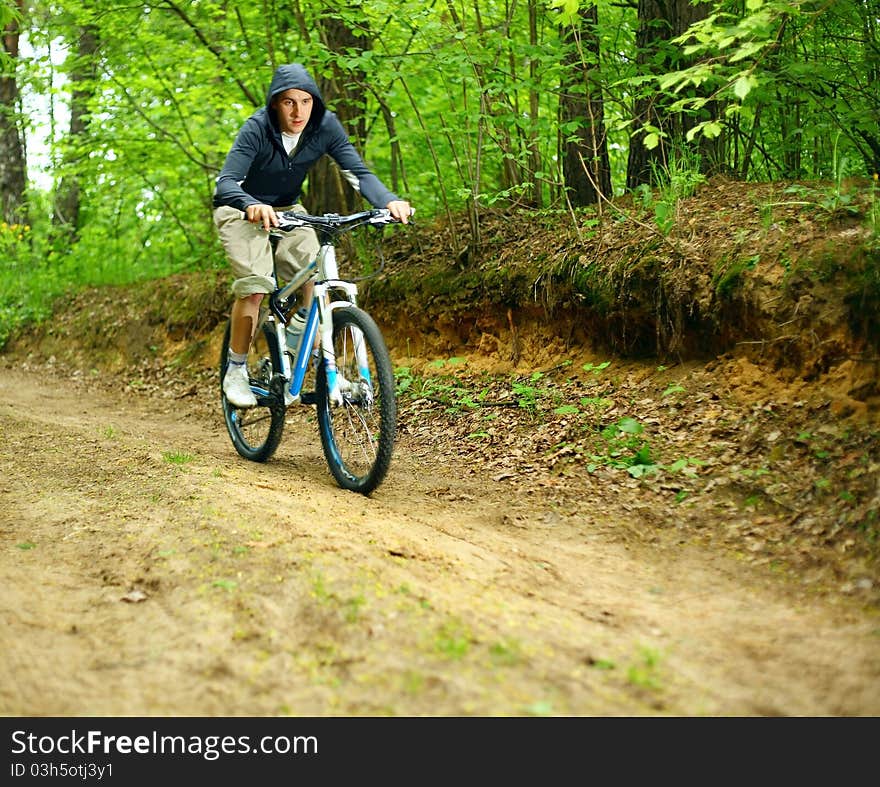 Young man on a bicycle in forest