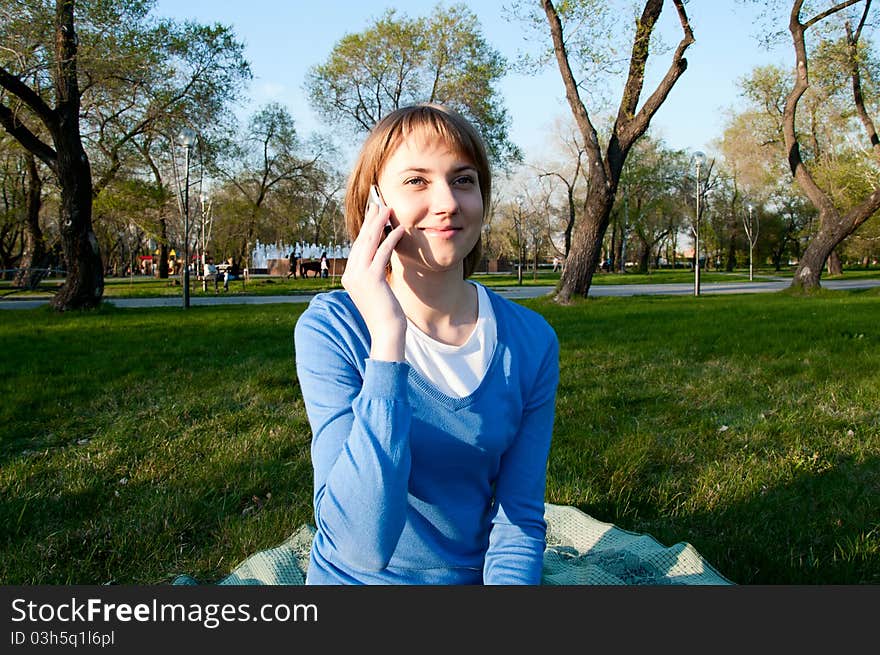 Girl Talking With A Cell In The Park