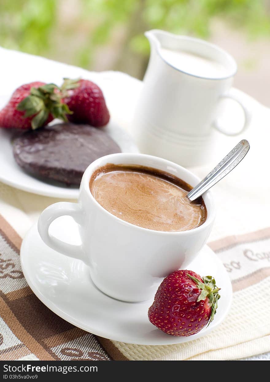 A cup of fresh white coffee with strawberry