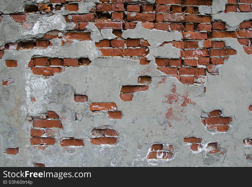 Partially plastered wall with red bricks