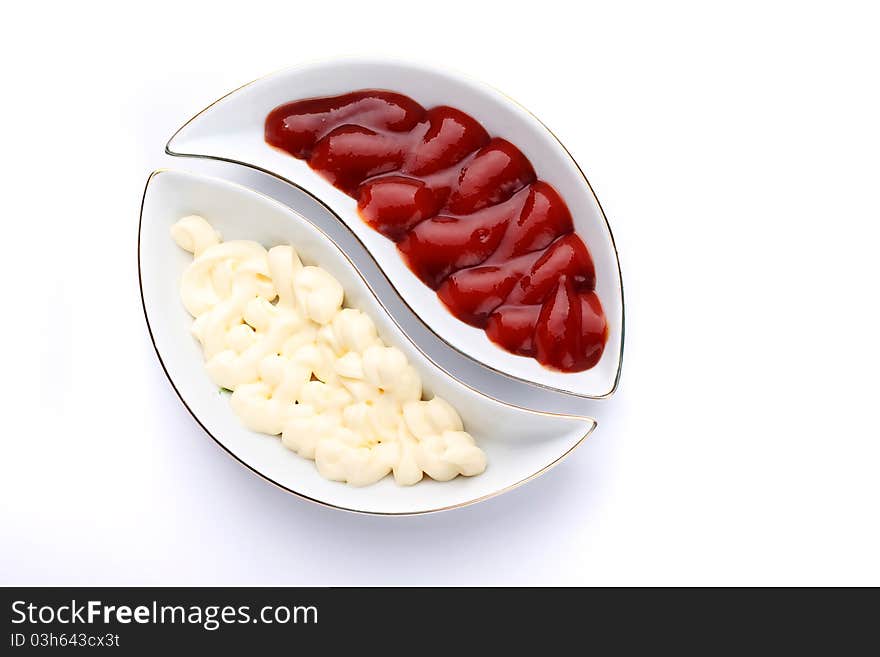 Mayonnaise and ketchup in a wavy plates on a white background. Mayonnaise and ketchup in a wavy plates on a white background