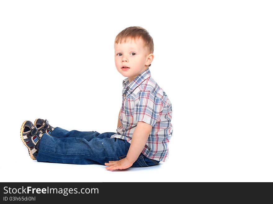 Cute little boy sitting isolated on white background. looking at camera. concept. Cute little boy sitting isolated on white background. looking at camera. concept.