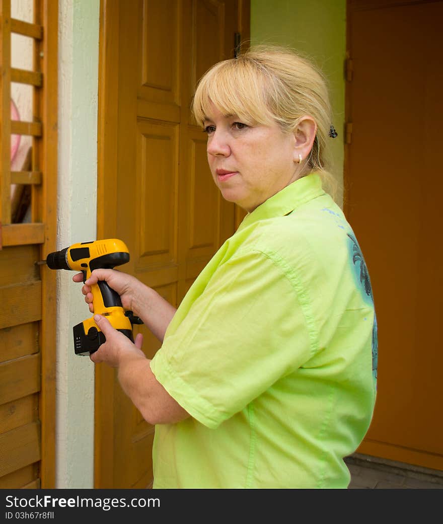 A woman with a screwdriver with power tool