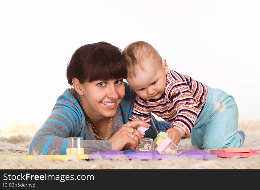 Happy mother and child playing on the carpet. Happy mother and child playing on the carpet