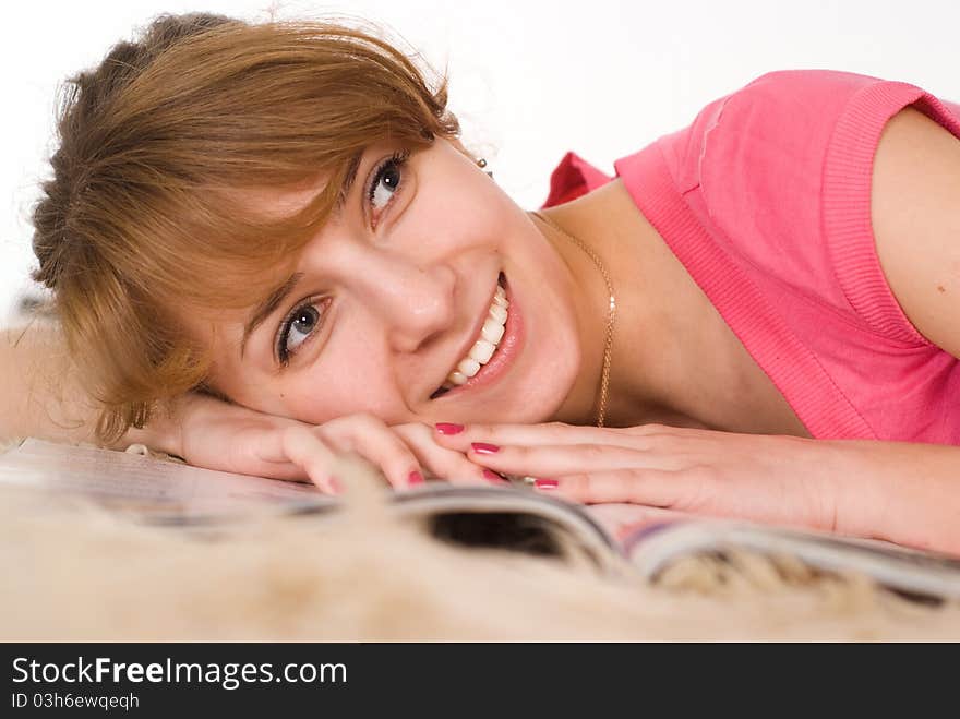 Pretty girl reading a magazine on the carpet. Pretty girl reading a magazine on the carpet