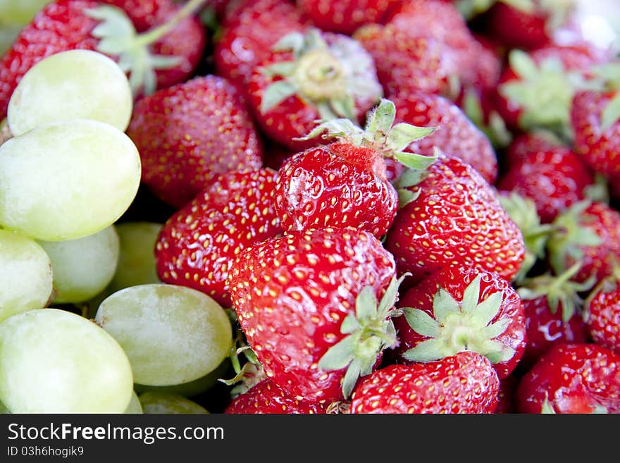 Fresh green vine and fresh red strawberry on a dish. Fresh green vine and fresh red strawberry on a dish