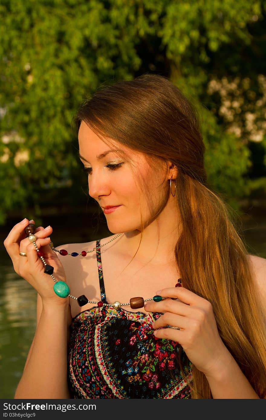 Portrait of a beautiful Russian girl with a beads on a background of green. Portrait of a beautiful Russian girl with a beads on a background of green