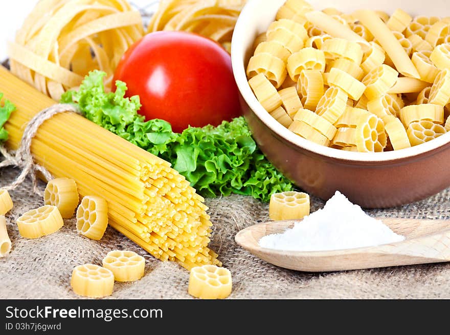 Composition of pasta, tomato, salt and salad