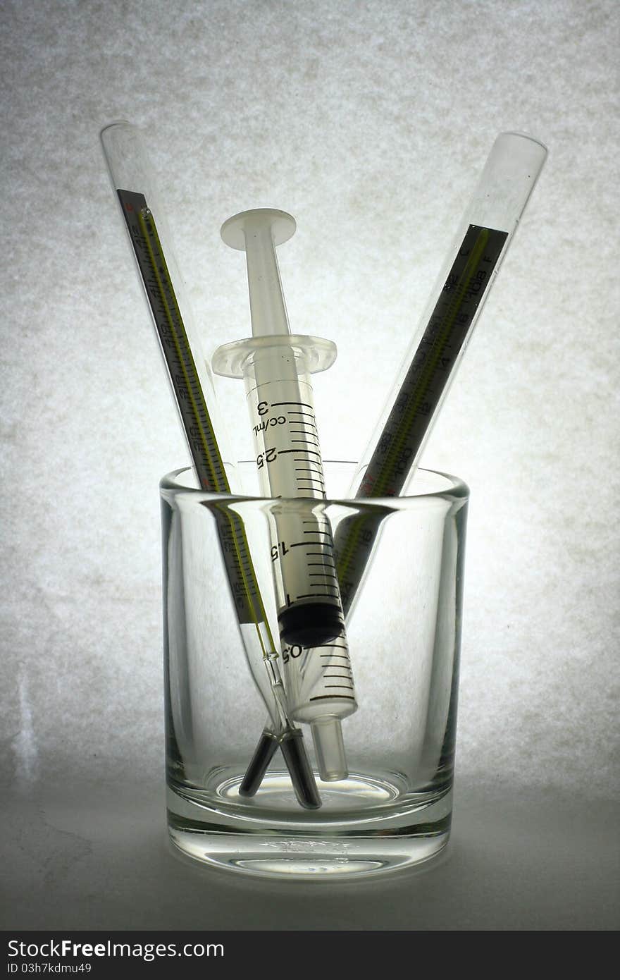 Syringe in glass on dark paper