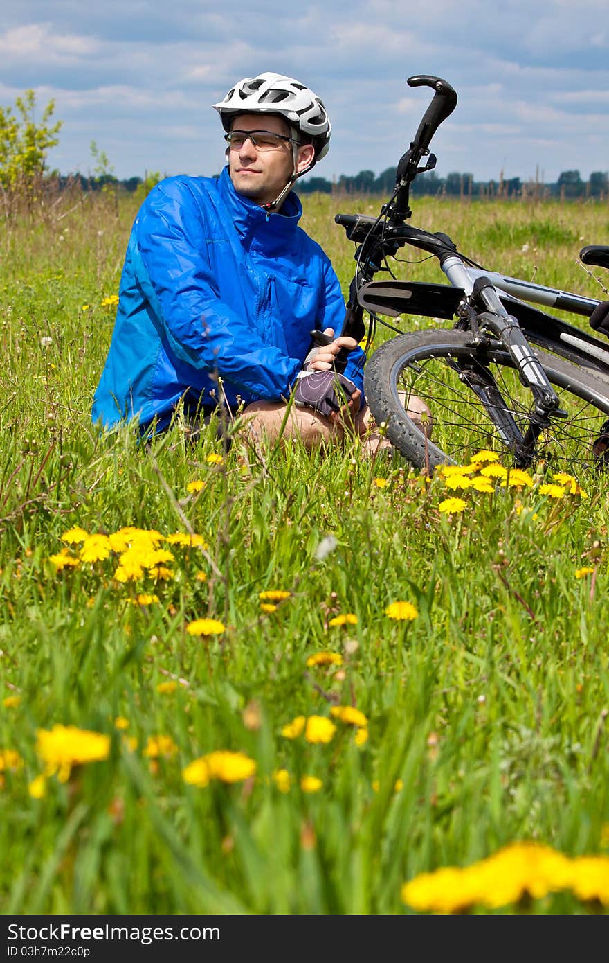 Mountain Biker Resting In A Grass