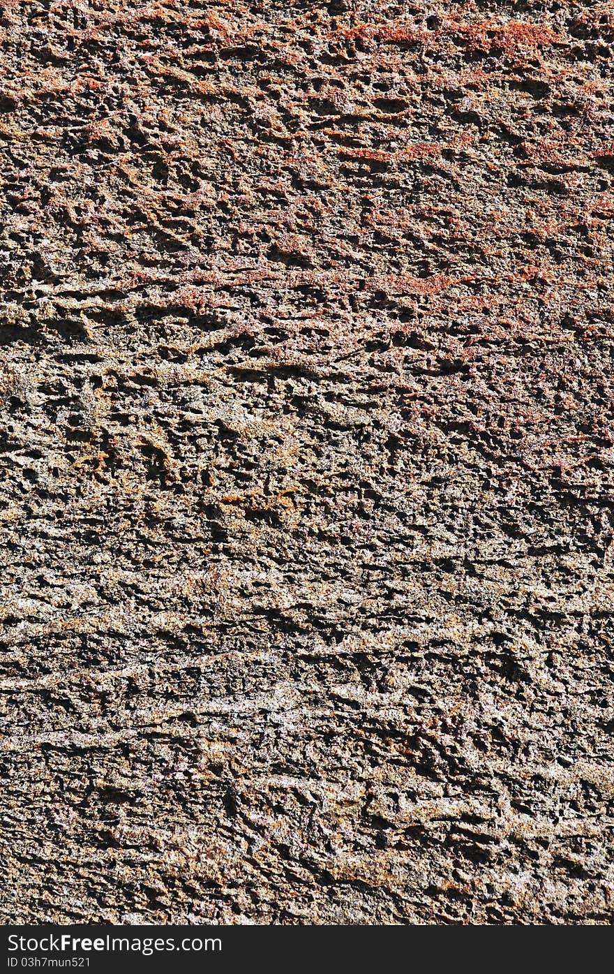 Fragment of natural rough brown stone surface. Fragment of natural rough brown stone surface