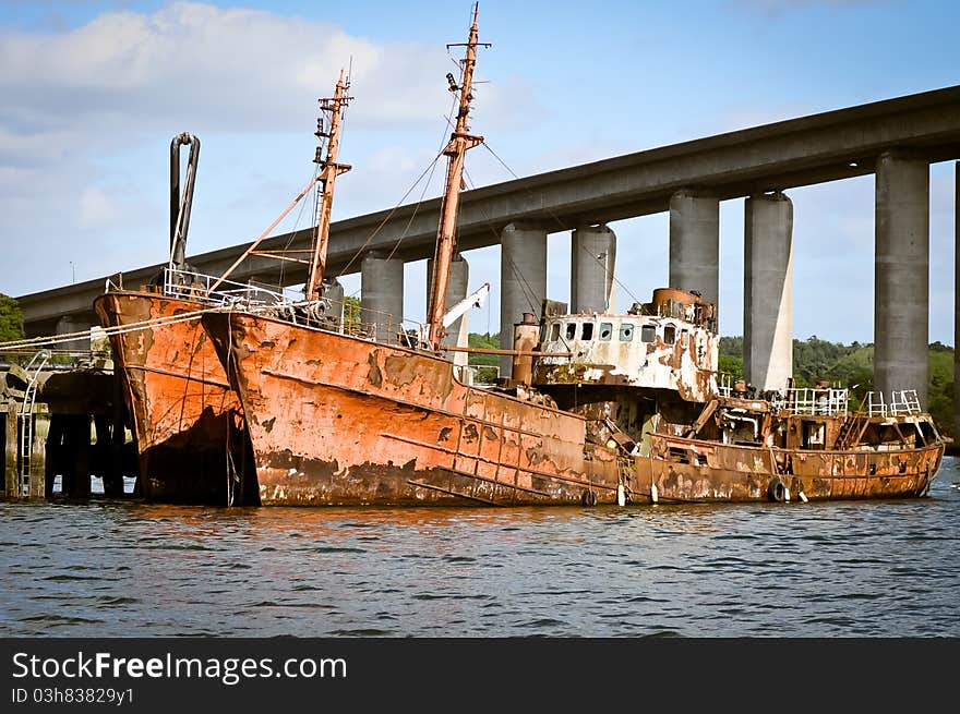 Old rusted ship, abandoned below the bridge