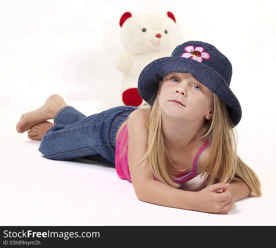 Little girl with playful denim hat and pink outfit on white background. Little girl with playful denim hat and pink outfit on white background.