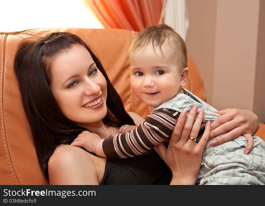 Mother with her sun sit on sofa and smiling. Mother with her sun sit on sofa and smiling