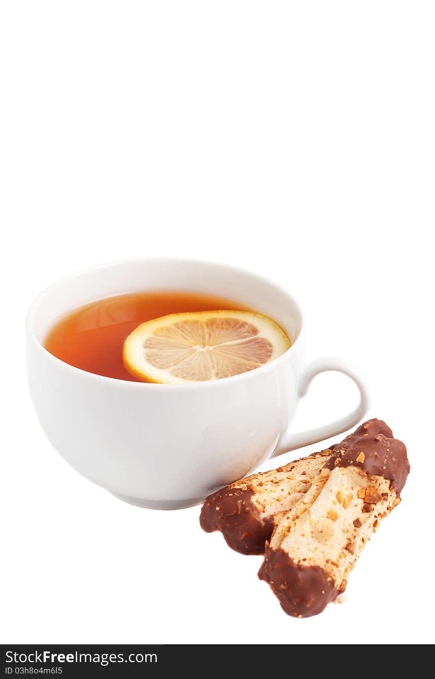 Cup of tea with lemon and chocolate dipped cookies on white background. Cup of tea with lemon and chocolate dipped cookies on white background