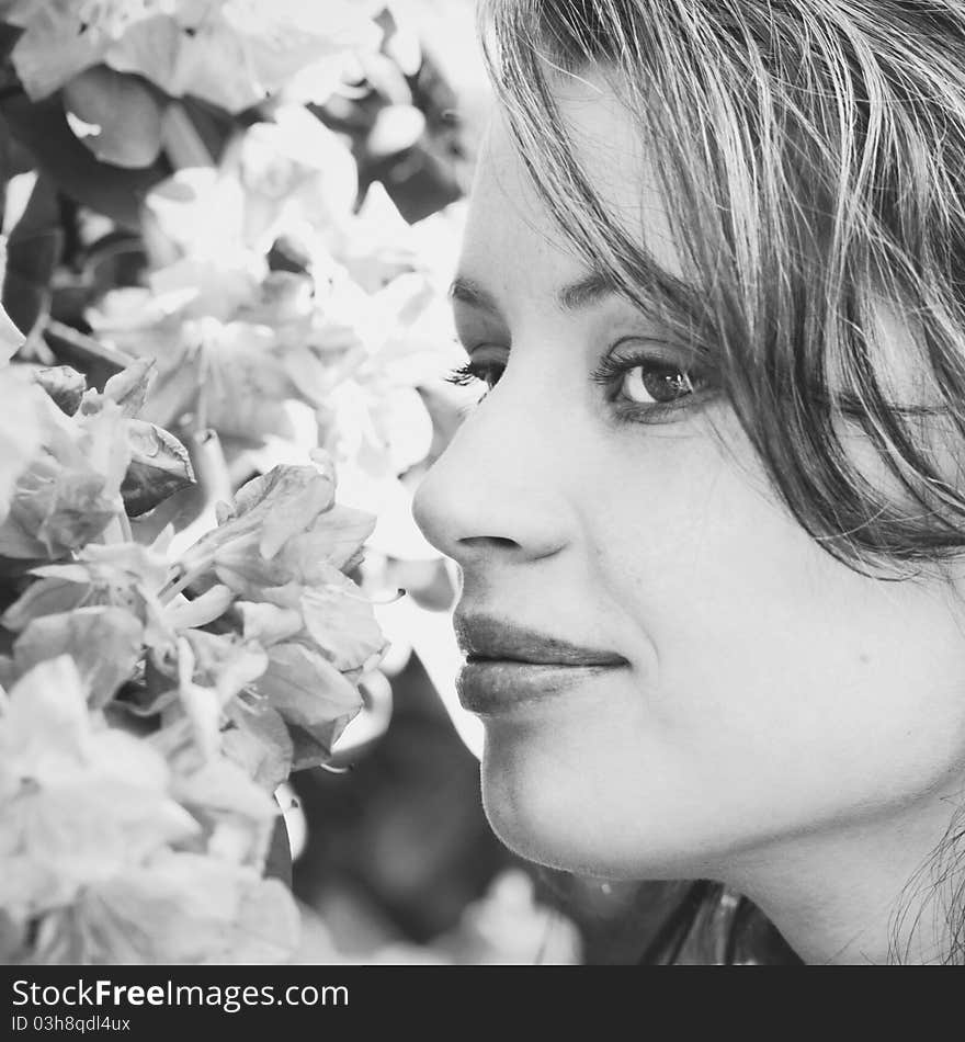 Beautiful young girl sniffing flowers of a tree in the park. Beautiful young girl sniffing flowers of a tree in the park