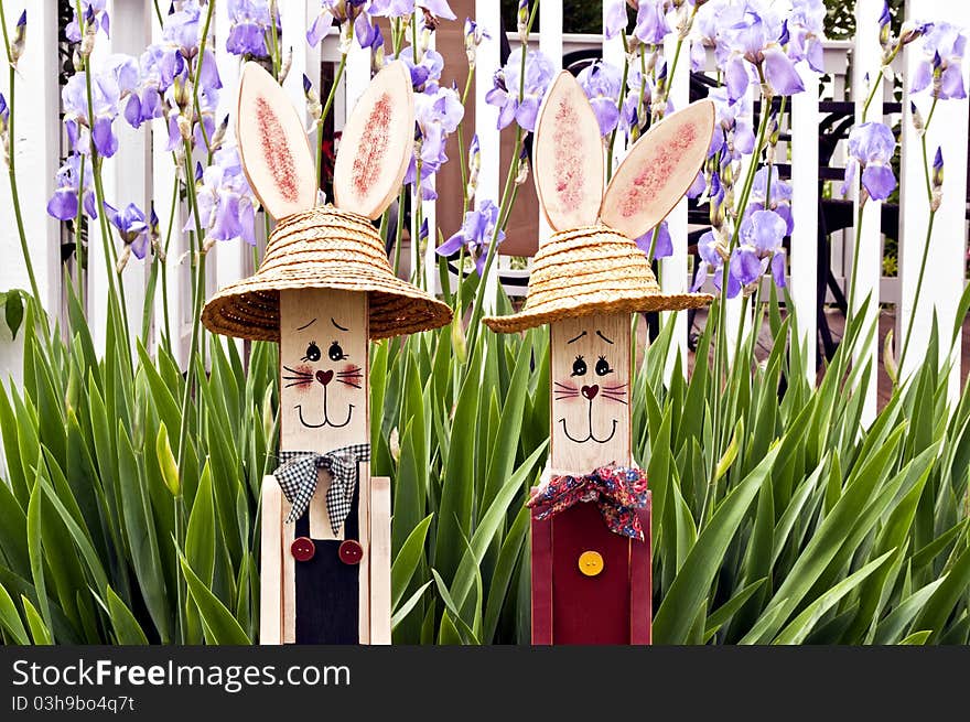 Two wood rabbit figures with spring flower background. Two wood rabbit figures with spring flower background