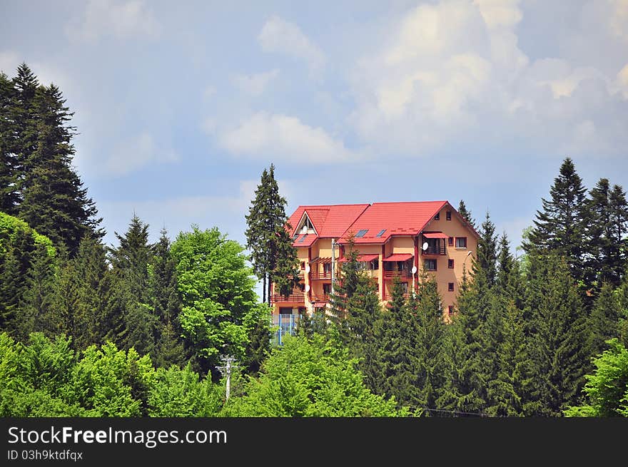 Red wooden cottage in the forest on mountain top. Red wooden cottage in the forest on mountain top