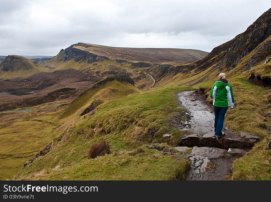 A woman hiking in the Quiraing Mountains on the Isle of Skye in Scotland, United Kingdom. A woman hiking in the Quiraing Mountains on the Isle of Skye in Scotland, United Kingdom.