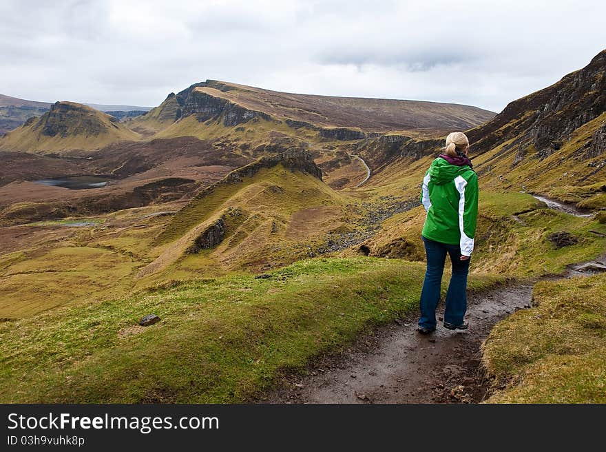 A woman hiking in the Quiraing Mountains on the Isle of Skye in Scotland, United Kingdom. A woman hiking in the Quiraing Mountains on the Isle of Skye in Scotland, United Kingdom.