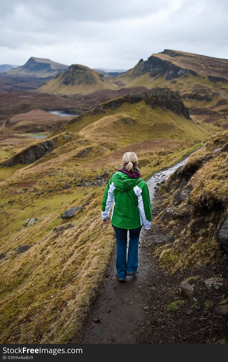 A woman hiking in the Quiraing Mountains on the Isle of Skye in Scotland, United Kingdom. A woman hiking in the Quiraing Mountains on the Isle of Skye in Scotland, United Kingdom.