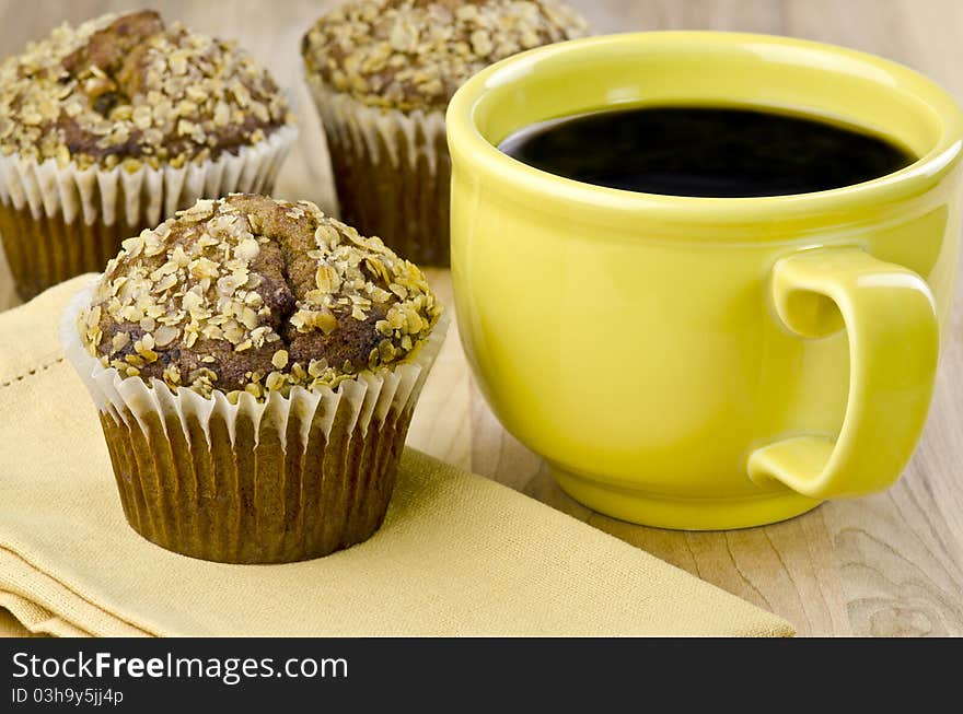 Bran muffins and a yellow cup with coffee. Bran muffins and a yellow cup with coffee