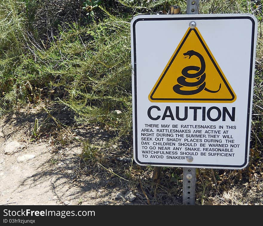 A Caution Sign warns Hikers to be alert for Rattlesnakes. A Caution Sign warns Hikers to be alert for Rattlesnakes.