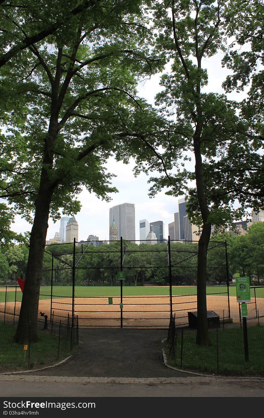 A baseball field in central park with 5th ave in the background. A baseball field in central park with 5th ave in the background