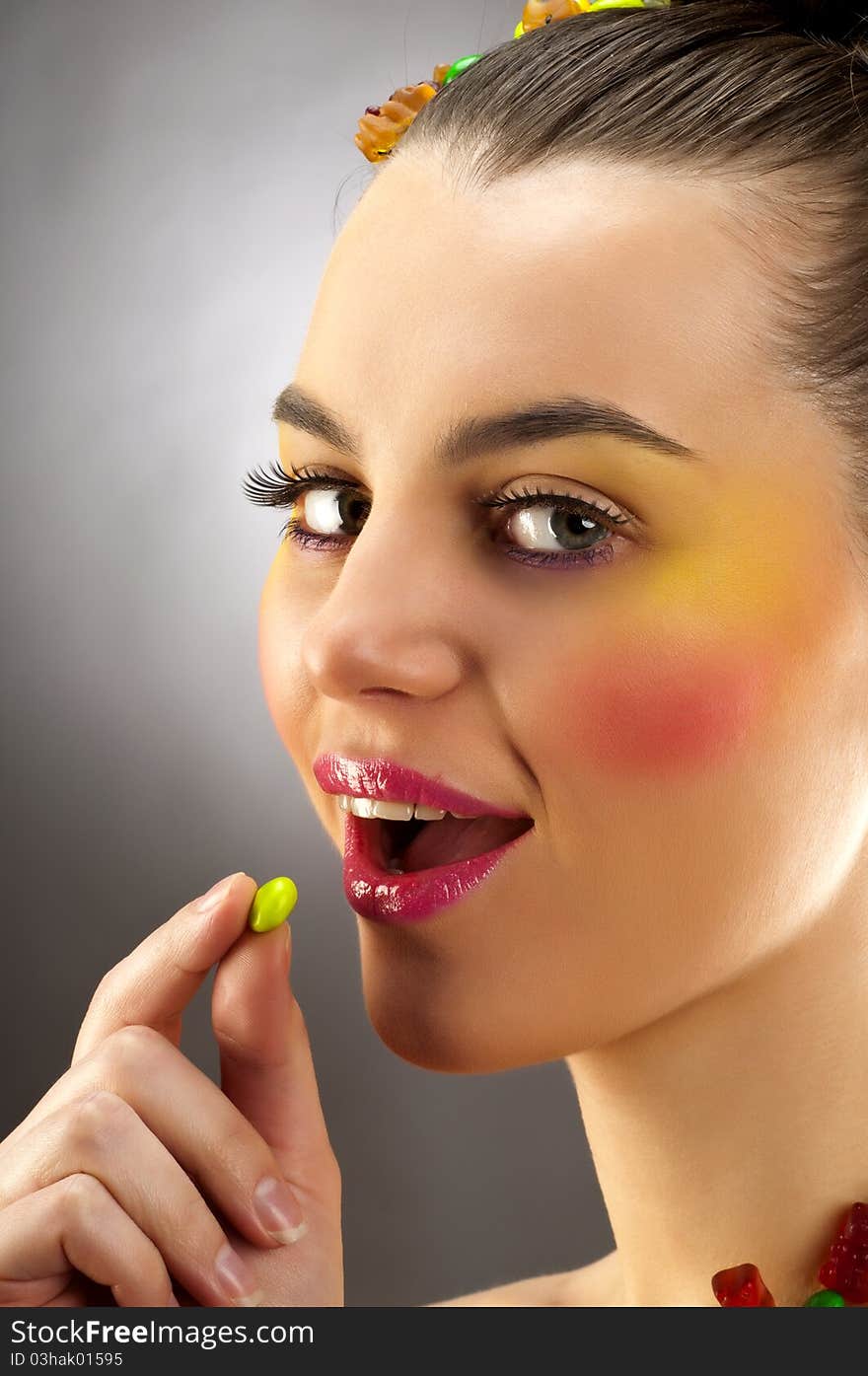 Close-up portrait of beautiful brunette with glamor make-up and color candy style