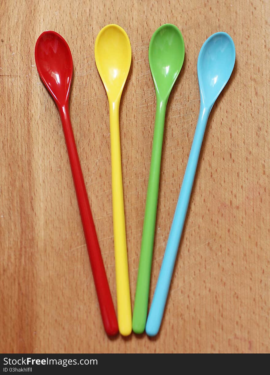 Red, yellow, green and blue spoons on the kitchen board. Red, yellow, green and blue spoons on the kitchen board