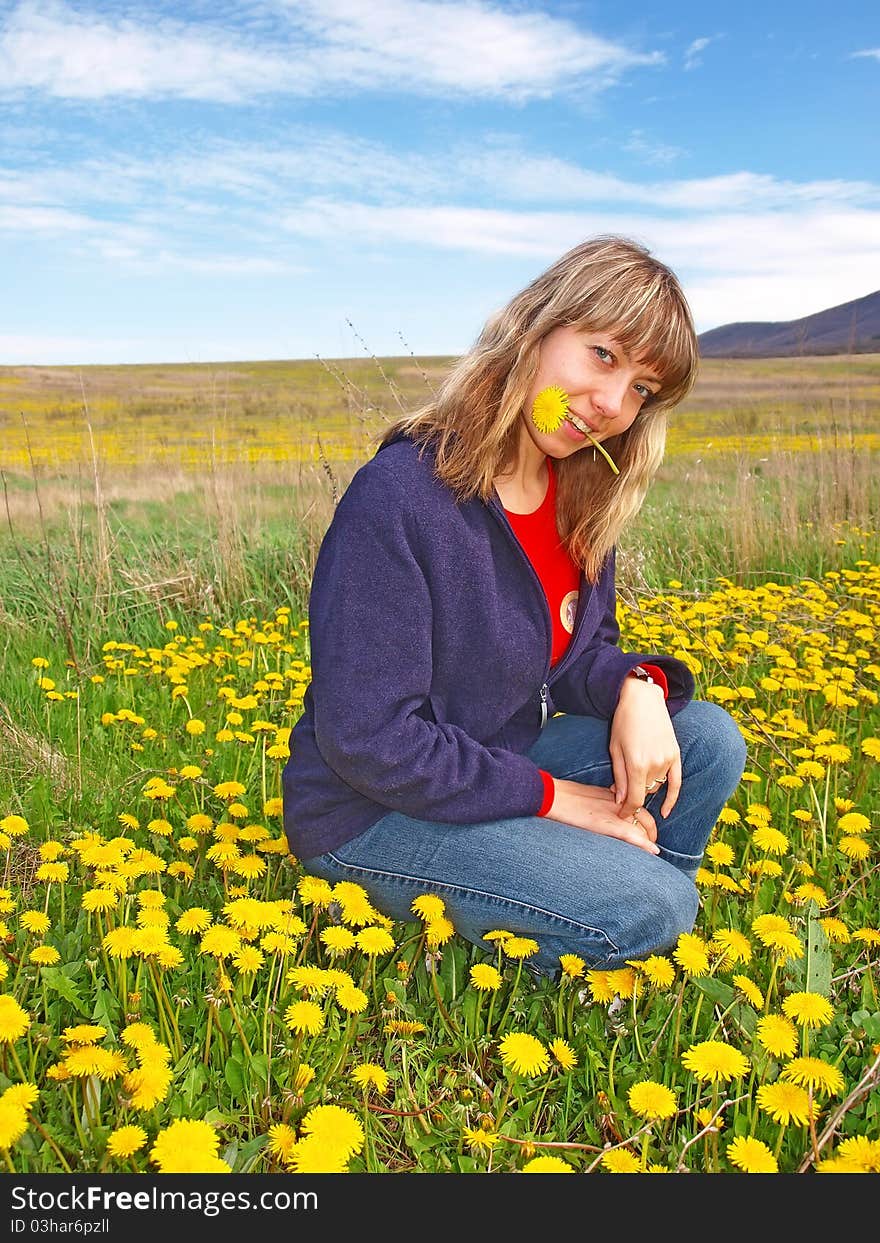 Beautiful girl on a dandelions field