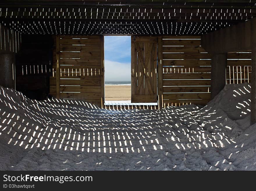 A unique view, with light, shadows and textures as seen from under a seaside boardwalk. A unique view, with light, shadows and textures as seen from under a seaside boardwalk