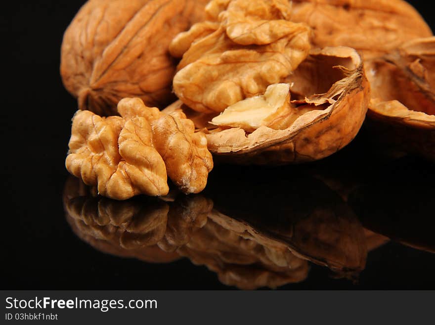 Walnuts. Close up on black reflecting background