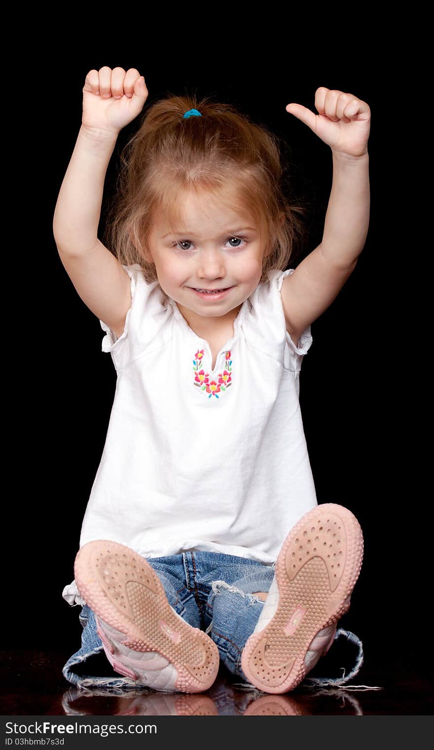 A girl is sitting down and could be holding something. A girl is sitting down and could be holding something.