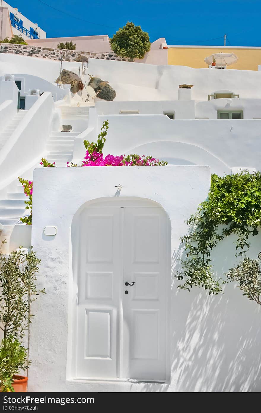 Famous white and traditional architecture with colorful flowers on island of Santorini in Fira, Greece. Famous white and traditional architecture with colorful flowers on island of Santorini in Fira, Greece.