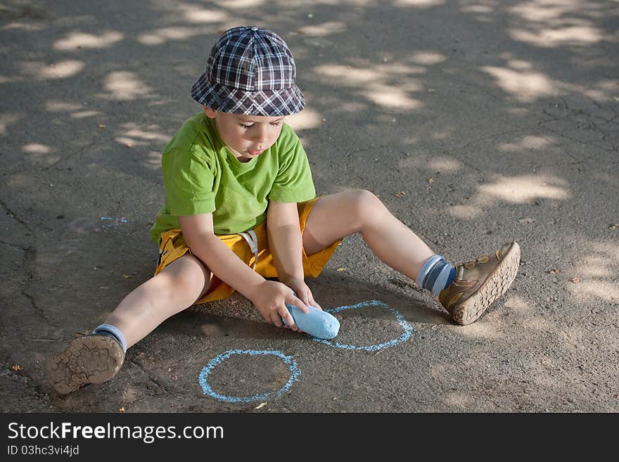 Boy drawing with chalk on asphalt