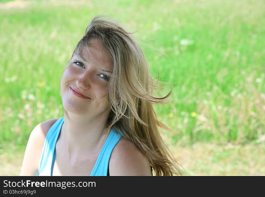 Summer portrait young happy woman against green grass