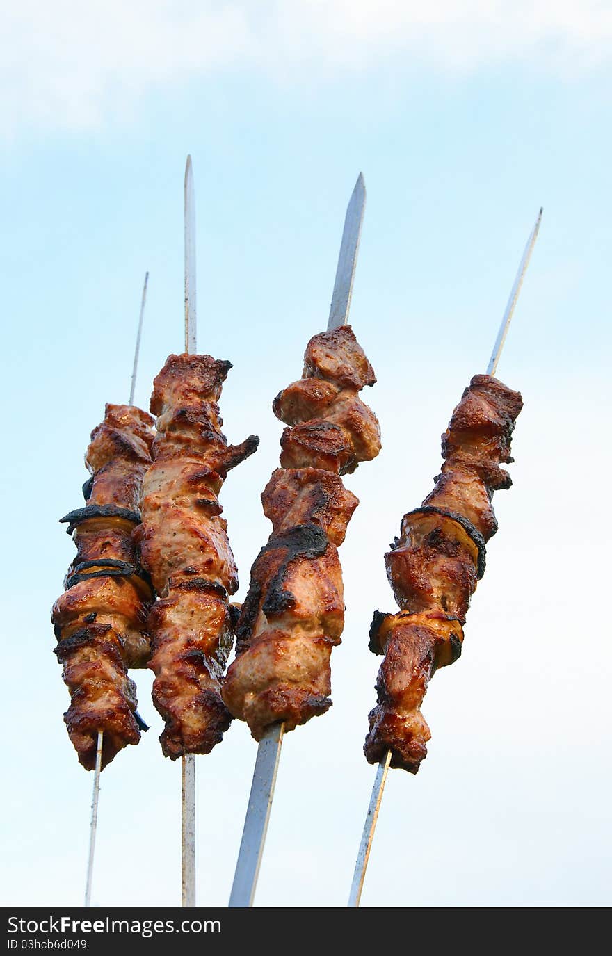 Grilled delicious kebabs over grill of a background