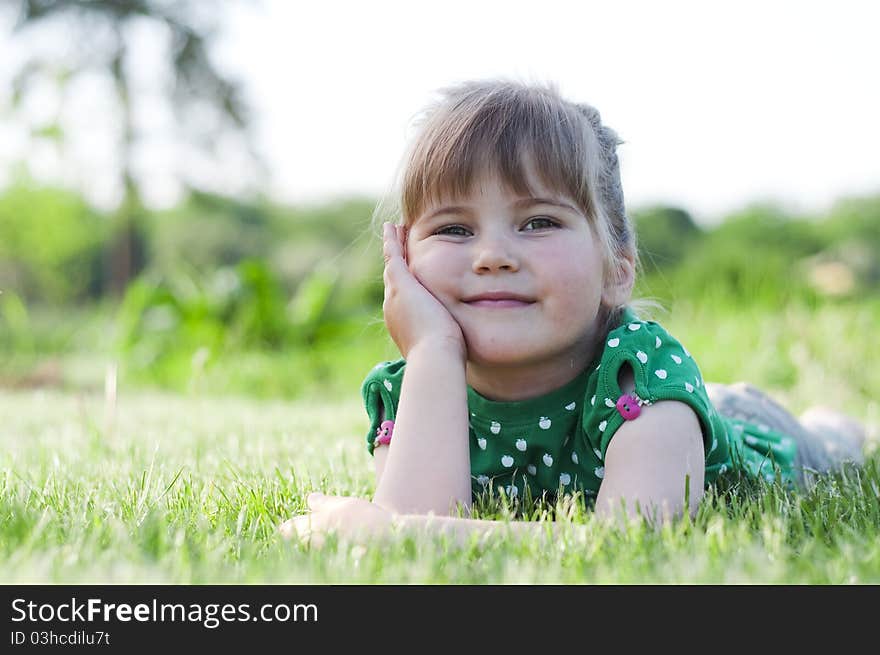 Little adorable girl lying on grass in the park. Little adorable girl lying on grass in the park